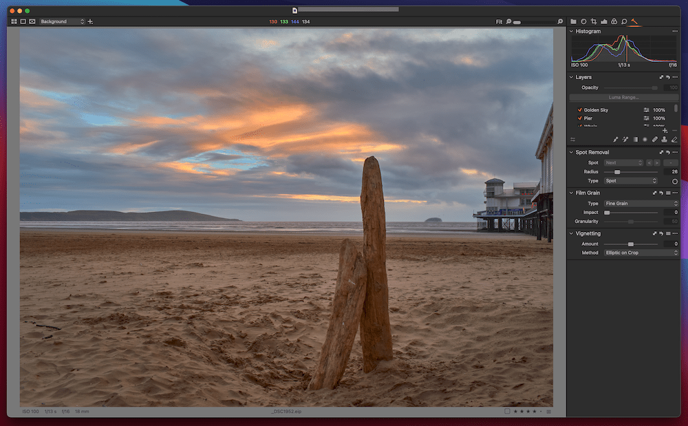 Пример редактирования файла RAW в Capture One, открытого для изображения двух стоящих коряг на пляже на закате." width="1000" height="619" />
 
<figcaption id=