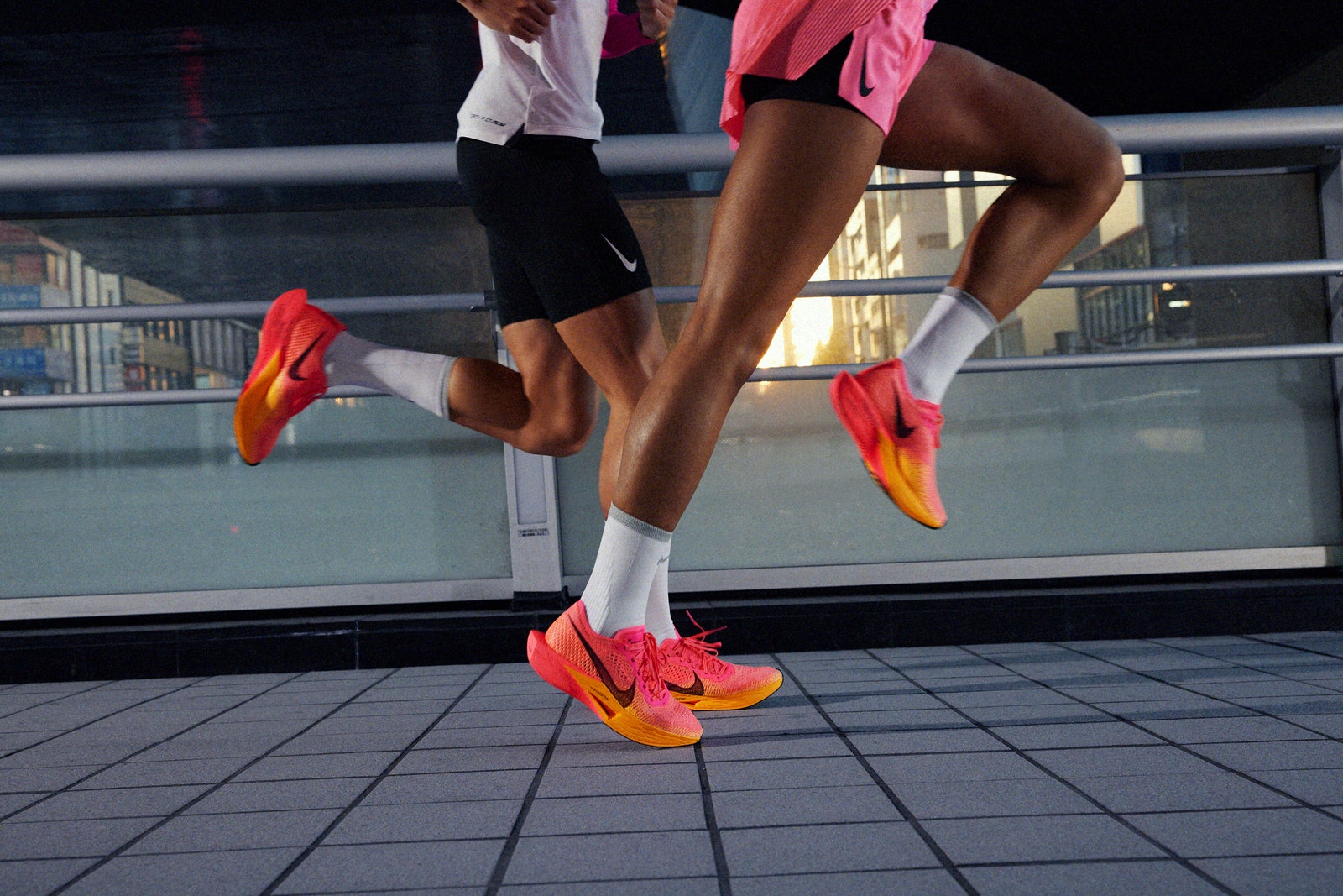Два человека бегут в кроссовках Nike ZoomX VaporFly Next.