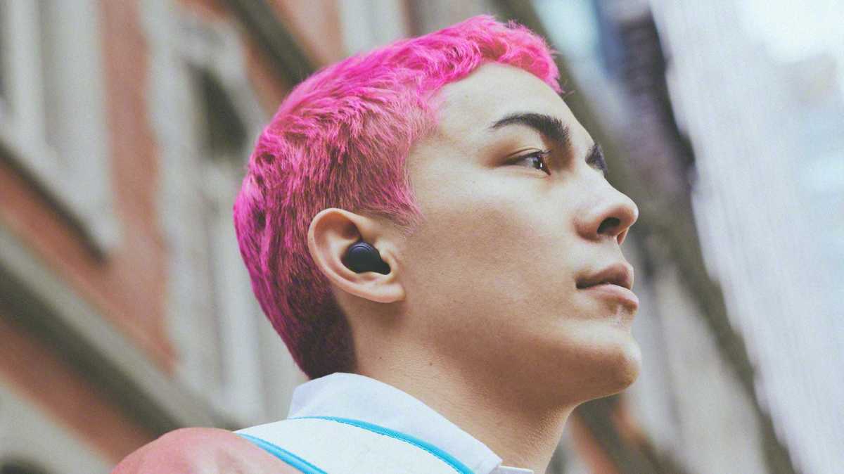 Человек с розовыми волосами в беспроводных наушниках Sony Wf-C700N