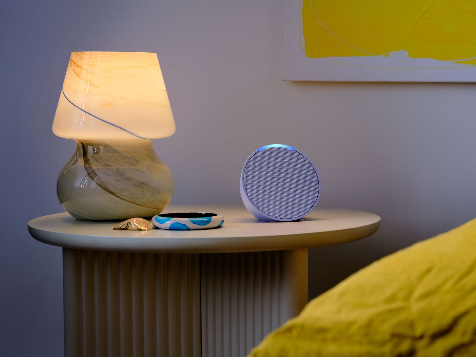 Amazon Echo Pop на ночном столике рядом с кроватью